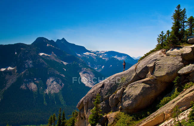 Escursionista in piedi sulla roccia in pendenza e guardando vista panoramica — Foto stock