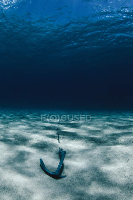 Under water view of anchor in sand — Stock Photo