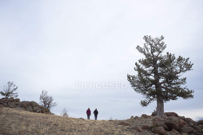 Vista lejana de la gente caminando en la montaña - foto de stock