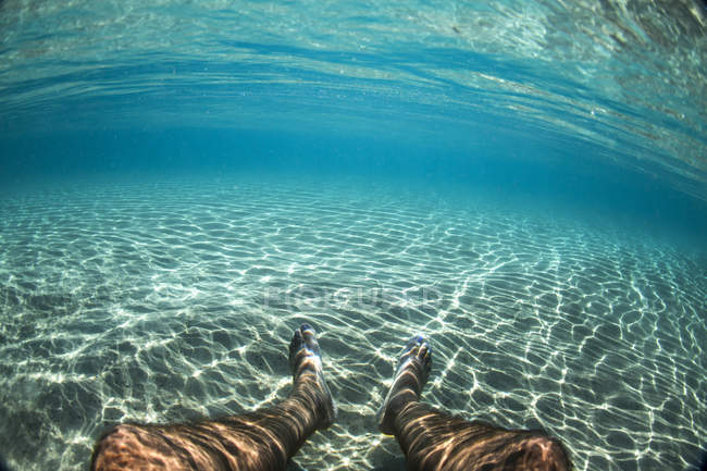 Abgeschnittenes Bild eines unter blauem Wasser liegenden Mannes — Stockfoto