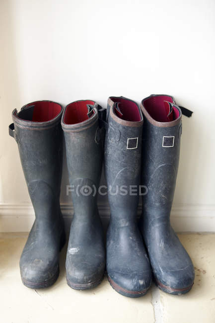 Two pairs of Wellington Boots standing on floor indoors — Stock Photo
