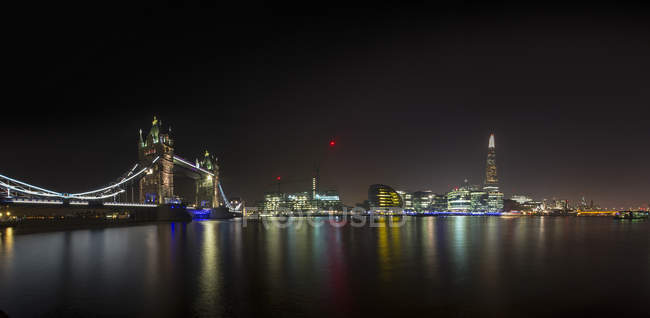 Illuminated London Bridge and Shard building by night and River Thames in foreground, London, USA — Stock Photo