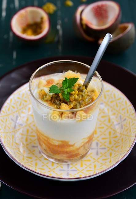 Ricotta cheese cream with honey, peach, passion fruit and mint in glass on plate — Stock Photo