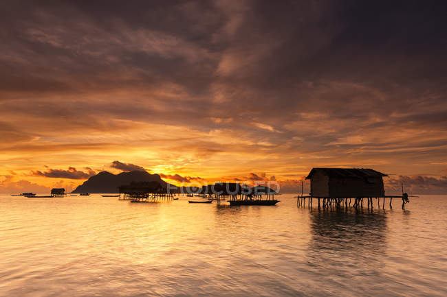 Malaysia, Sabah, scenic view of sea gypsy huts at sunrise — Stock Photo