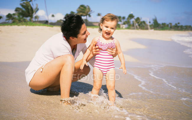 Madre e figlia rilassarsi sulla spiaggia — Foto stock