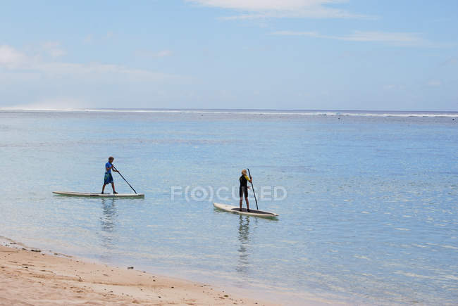 Rapaz e menina paddle boarding, Ilhas Cook — Fotografia de Stock