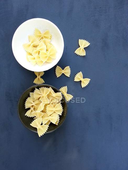 Studio shot of farfalle pasta over blue background, top view — Stock Photo