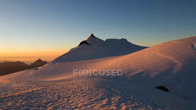 Suiza, Allalinhorn, Los Alpes, Wallis, vista panorámica de las montañas nevadas al amanecer - foto de stock