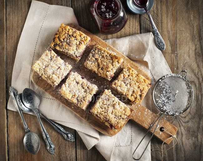 Cut black currant crumble cake on wooden table — Stock Photo