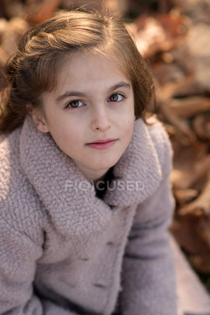 Симпатична дівчина сидить в осінньому листі — стокове фото