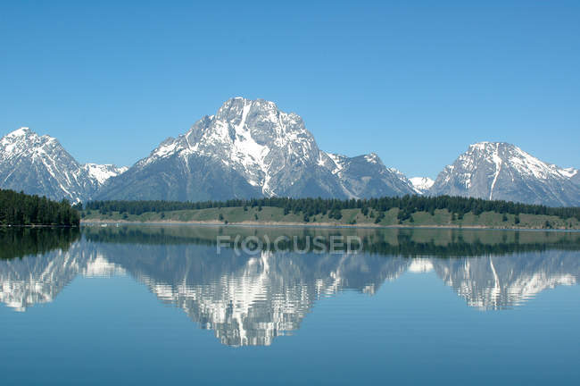 USA, Grand Tetton Nationalpark, schneebedeckte Berge, die sich im Jackson Lake spiegeln — Stockfoto