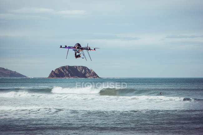 Drone flying over waving sea at cloudy day — Stock Photo