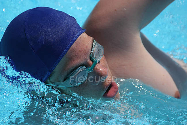Primer plano del nadador con gorra de natación y gafas de natación en el agua - foto de stock