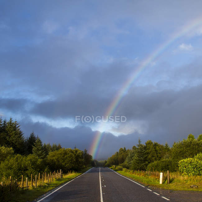 Vista panorámica de Rainbow sobre carretera, Escocia, Reino Unido - foto de stock