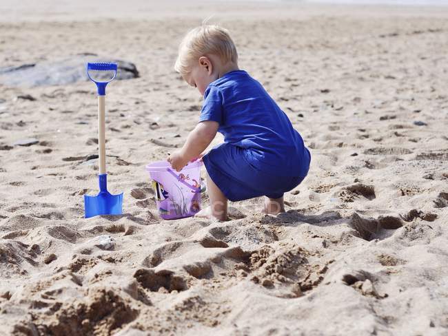 Маленький хлопчик грає в пісок на пляжі — стокове фото