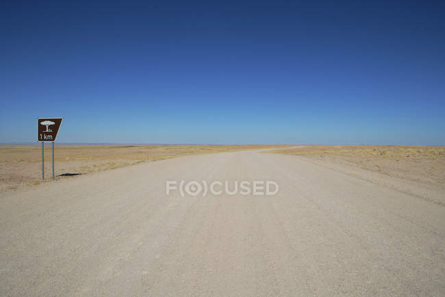 Vista panorâmica ao longo da estrada deserta vazia com sinal de área de descanso, Namíbia — Fotografia de Stock