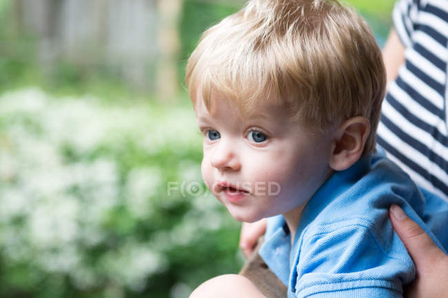 Блондинка маленький хлопчик дивиться в парк — стокове фото