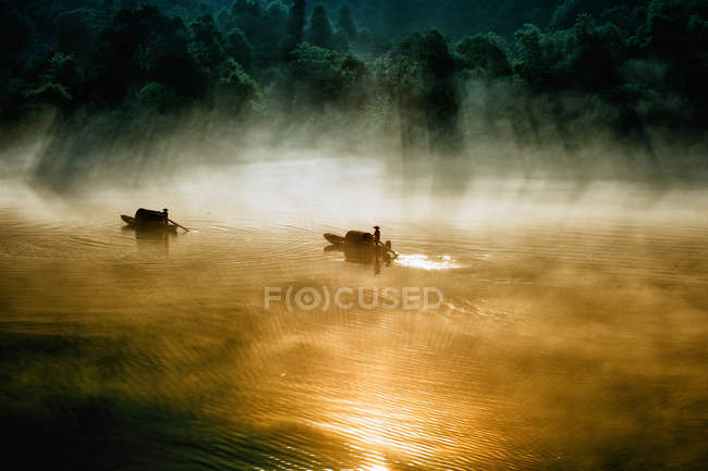 Vista maestosa di due barche a remi che attraversano lago nebbioso, Lago Dongjiang, Chenzhou, Hunan, Cina — Foto stock