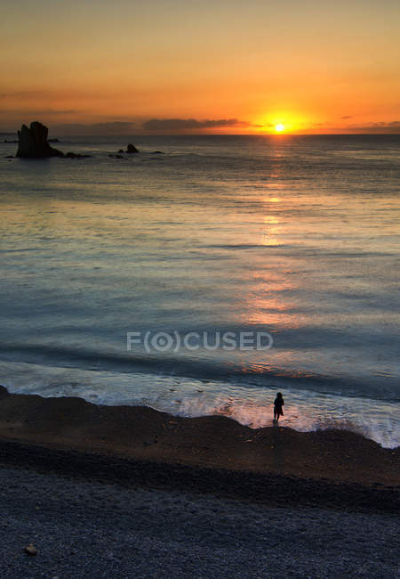 Spagna, Asturie, Playa del Silencio, veduta panoramica del paesaggio marino e persona silhouette al tramonto — Foto stock