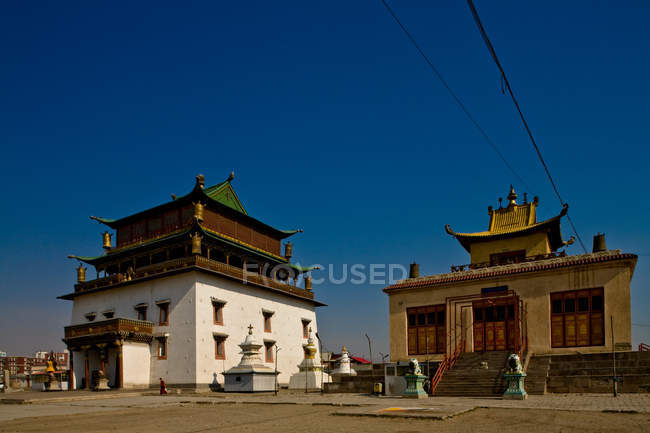 Vista panorámica de dos edificios contra el cielo despejado, templo principal, monasterio de Gandan Khiid, Ulan Bator, Mongolia - foto de stock