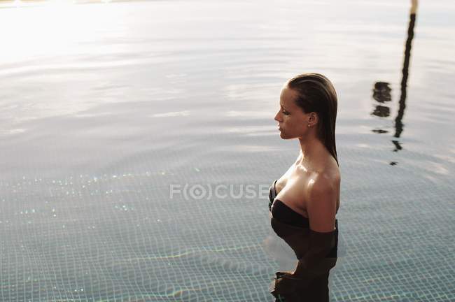 Attrayant femme debout dans une piscine — Photo de stock