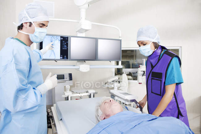 Взрослая женщина врач с пациентом в комнате с медицинским оборудованием — стоковое фото