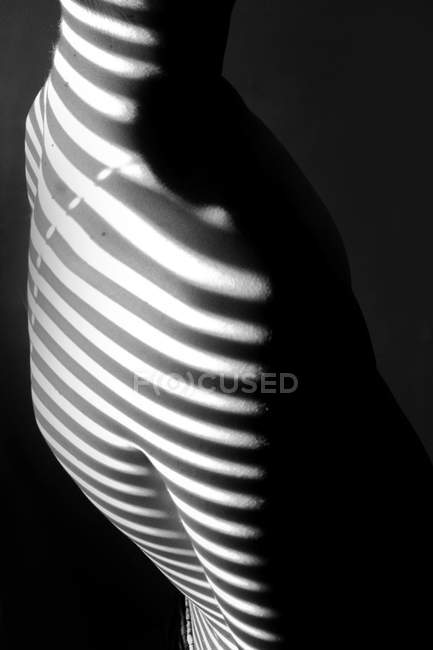 Cropped image of Shadow lines from blinds on boy back — Stock Photo
