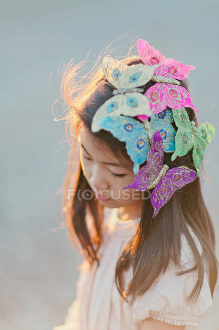Nahaufnahme eines Mädchens mit geschmückten Schmetterlingen auf dem Haar — Stockfoto
