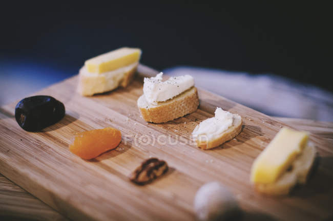 Sanduíches com queijo e frutas secas na tábua de corte — Fotografia de Stock