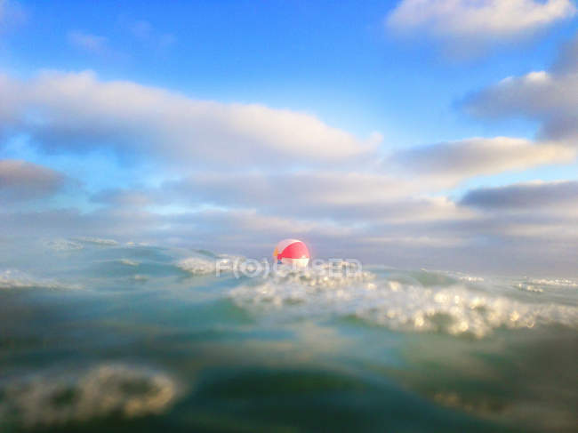 Vista panorámica de la bola de playa flotando en el mar - foto de stock