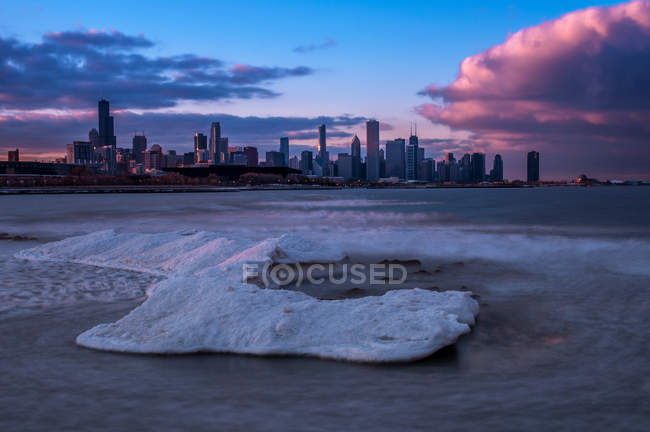 Downtown skyline with pink sunset clouds seen from across lake bay, USA, Illinois, Chicago — Stock Photo