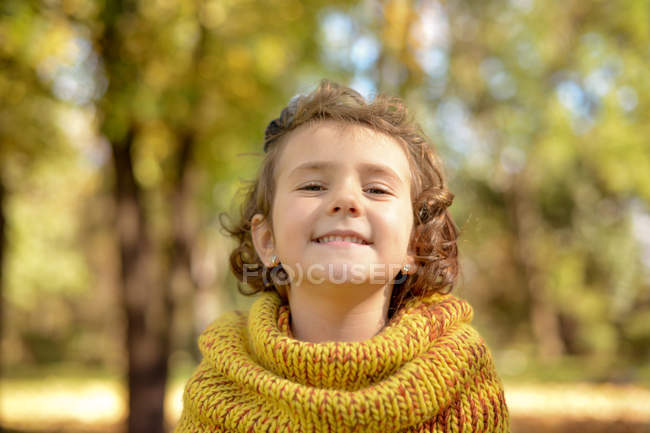 Portrait de jolie petite fille souriant dans le parc — Photo de stock