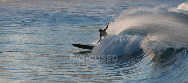 Silhouette del surfista in equilibrio sull'onda nell'oceano — Foto stock