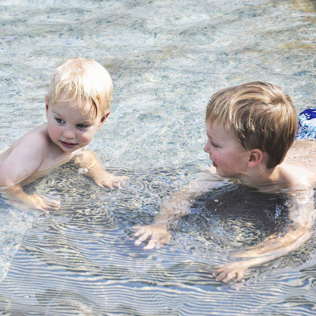 Dois jovens irmãos caucasianos se divertindo na água — Fotografia de Stock