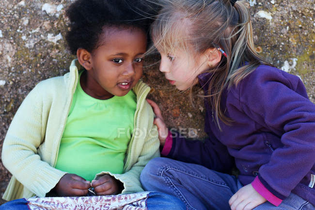 Zwei süße kleine Freundinnen lehnen sich aneinander — Stockfoto
