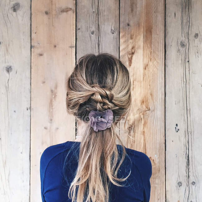 Vista posteriore della ragazza con fiore nei capelli — Foto stock