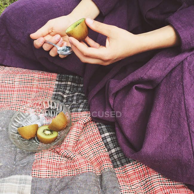 Close-up of a woman eating a kiwi fruit — Stock Photo