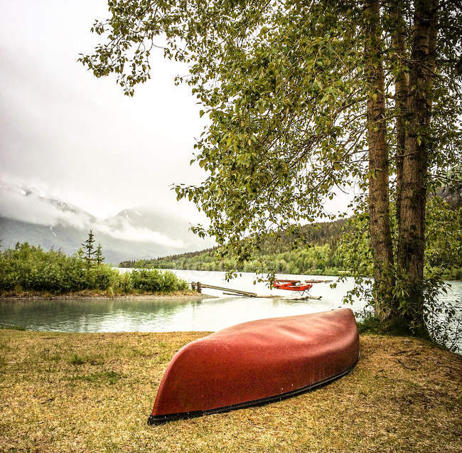 Canoa roja y un hidroavión, Alaska, EE.UU. - foto de stock