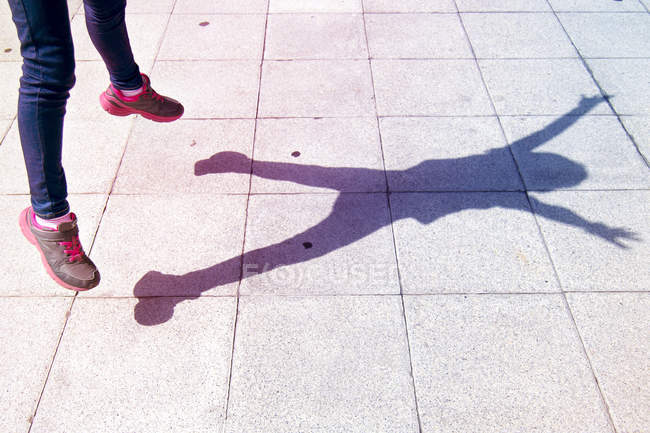 Shadow of girls legs jumping in air — Stock Photo
