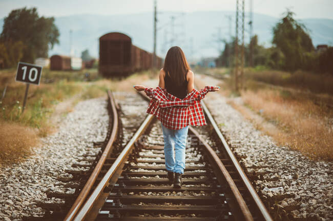 Fille marche sur le chemin de fer vu de dos — Photo de stock