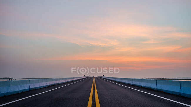 Route à travers l'autoroute avec beau fond de coucher de soleil — Photo de stock