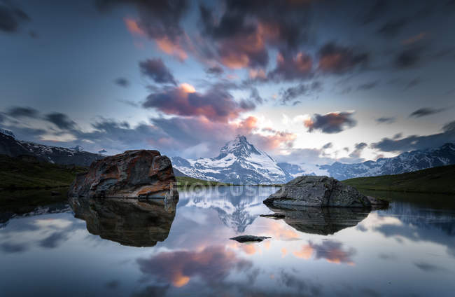 Beau ciel couchant, lac avec rocher — Photo de stock
