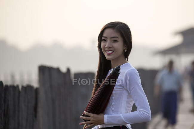 Retrato de una joven sonriente con paraguas - foto de stock