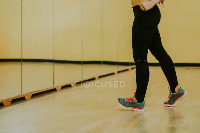 Menina na sala de fitness em pé na frente de um espelho — Fotografia de Stock
