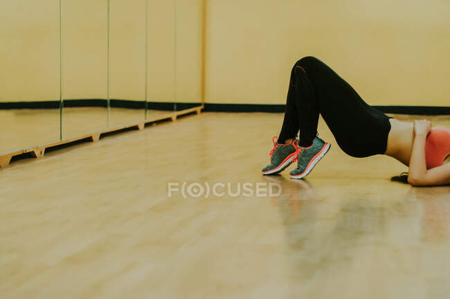 Menina na sala de fitness deitado na frente de um espelho — Fotografia de Stock