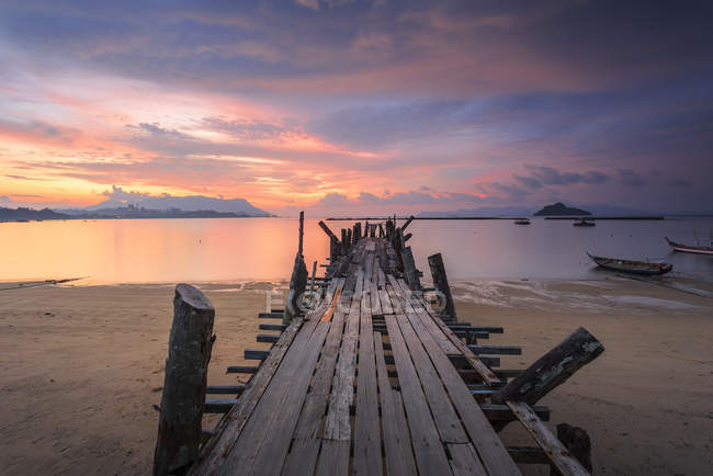 Красивий захід сонця Jetty в чорний пісок пляжу Village на острові Лангкаві, Малайзія. — стокове фото