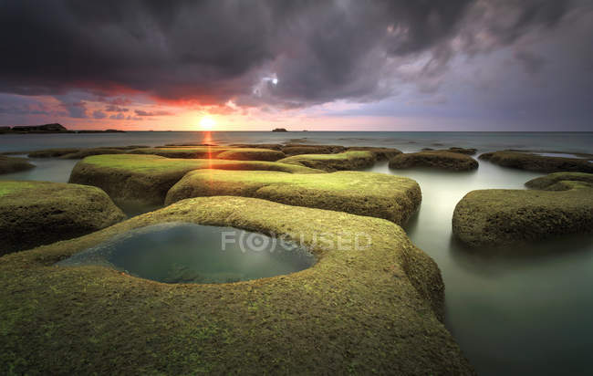 Massi di rocce con verde muschio vista tramonto sul mare a tindakon dazang Beach Kudat, sabah, Malesia — Foto stock