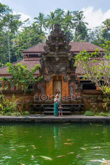 Visitors to Tirta Empul first come upon the lush gardens and pathways adorned with statues and tropical plants that lead to its entrance. — Stock Photo
