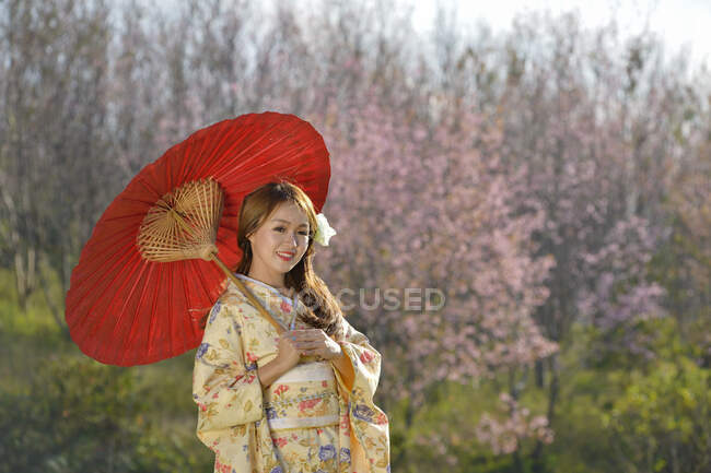 Fille japonaise en robe traditionnelle appelée Kimono avec Sakura fleur — Photo de stock