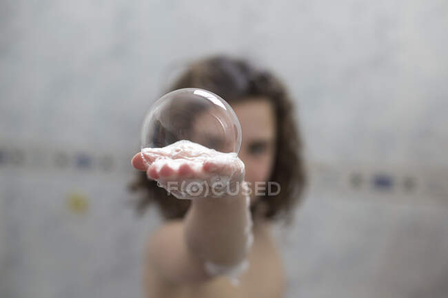 Mädchen in der Badewanne hält Seifenlauge in der Hand — Stockfoto